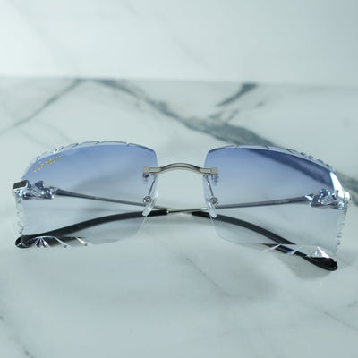 Close-Up of Cartier Leaping Panthère Silver Frames: Detailed close-up showcasing the exquisite silver frames of the Cartier Leaping Panthère glasses, accented with diamond-cut embellishments and blue gradient lenses.